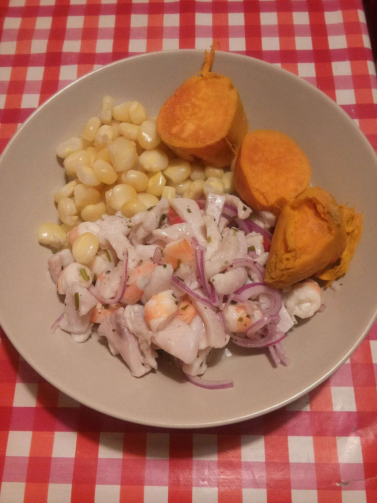Assiette de ceviche péruvien, poisson cru mariné au citron vert avec oignon rouge, maïs et patate douce