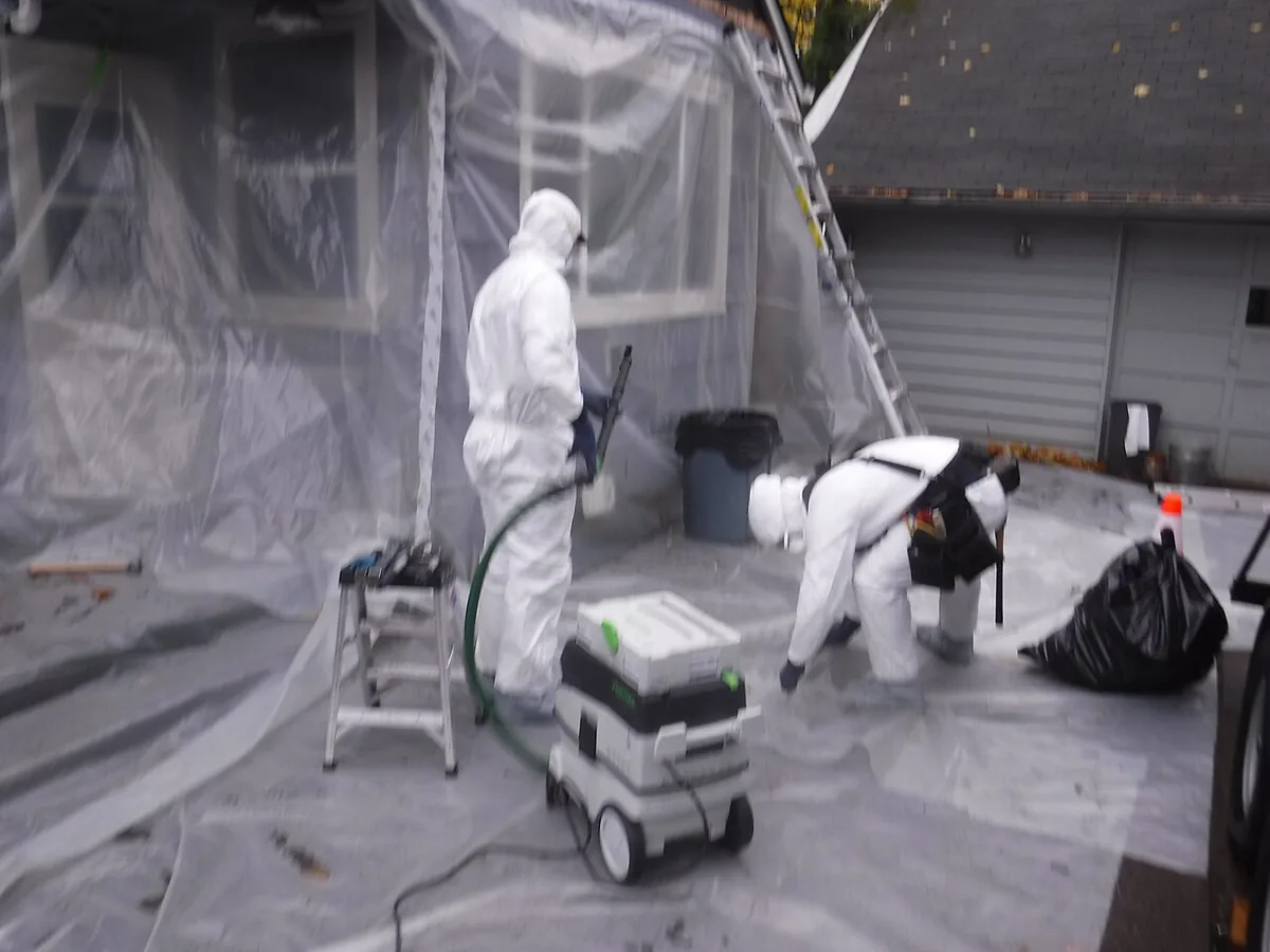Chantier de retrait de peinture au plomb dans un logement ancien, avec protections et équipement spécialisé