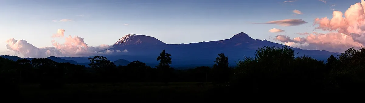 Les cônes du Kibo arrondi et du Mawenzi déchiqueté du massif du Kilimandjaro vus au-dessus des nuages