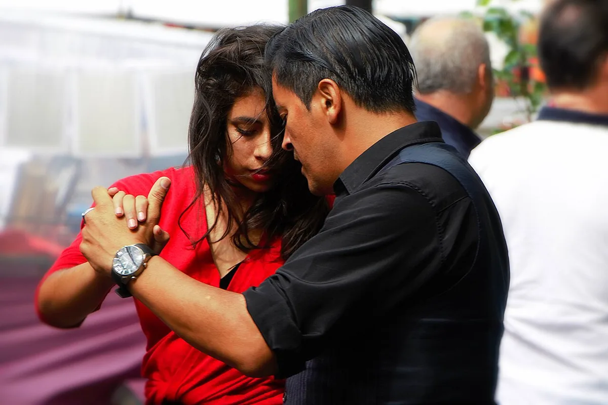 Couple dansant le tango dans une rue du quartier de La Boca à Buenos Aires, danse née de l'immigration