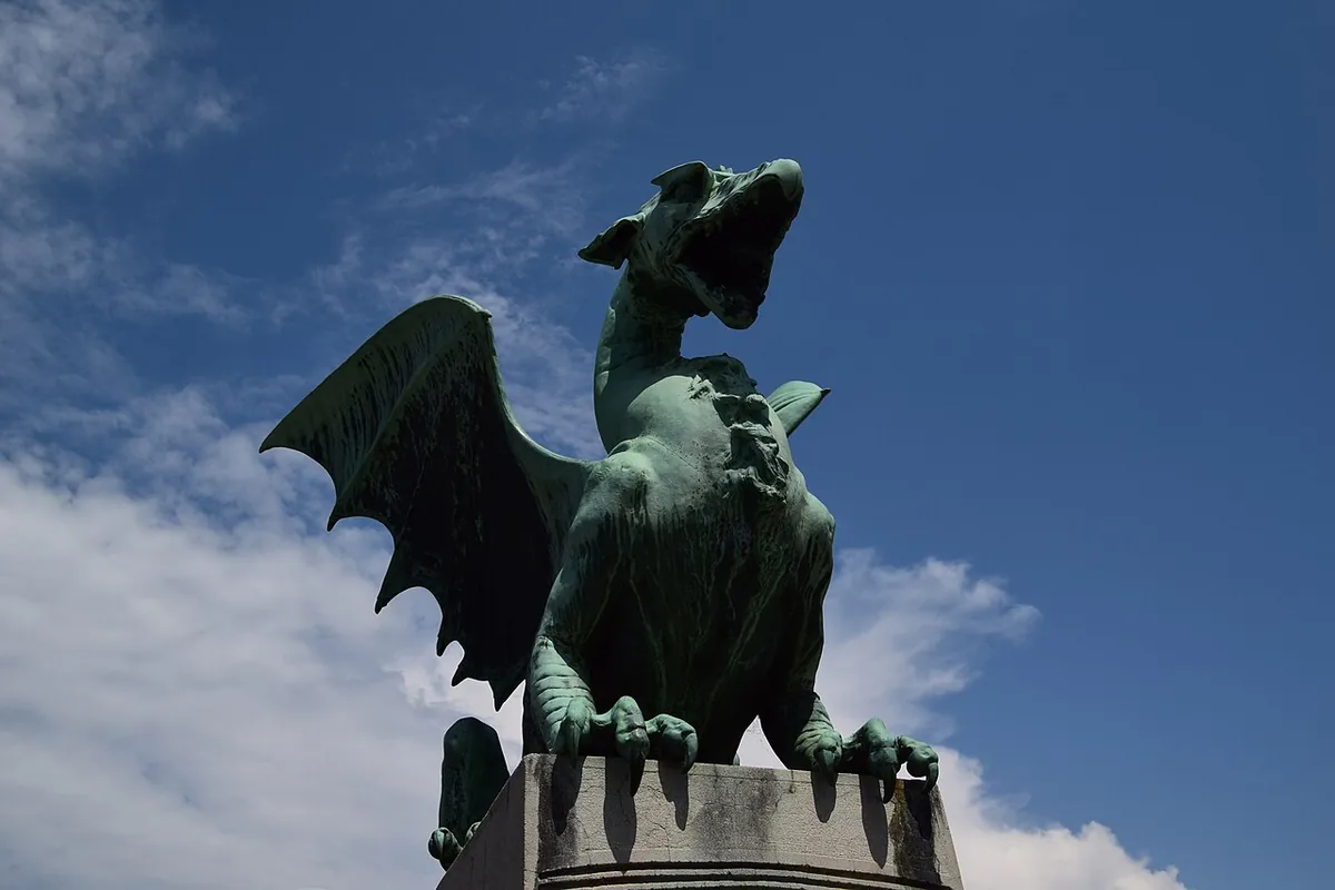 Dragon en bronze du pont des Dragons à Ljubljana avec architecture urbaine en arrière-plan