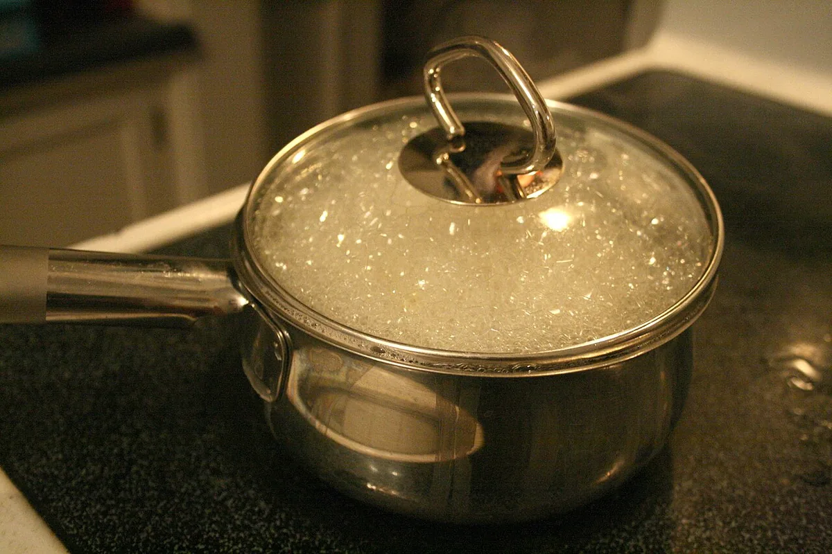 Eau en pleine ébullition dans une casserole, bulles remontant à la surface au point d'ébullition