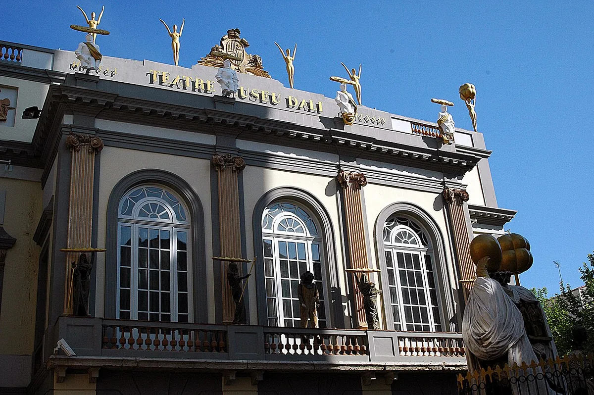 Façade rouge du Théâtre-musée Dalí à Figueres surmontée de grands œufs blancs sur le toit