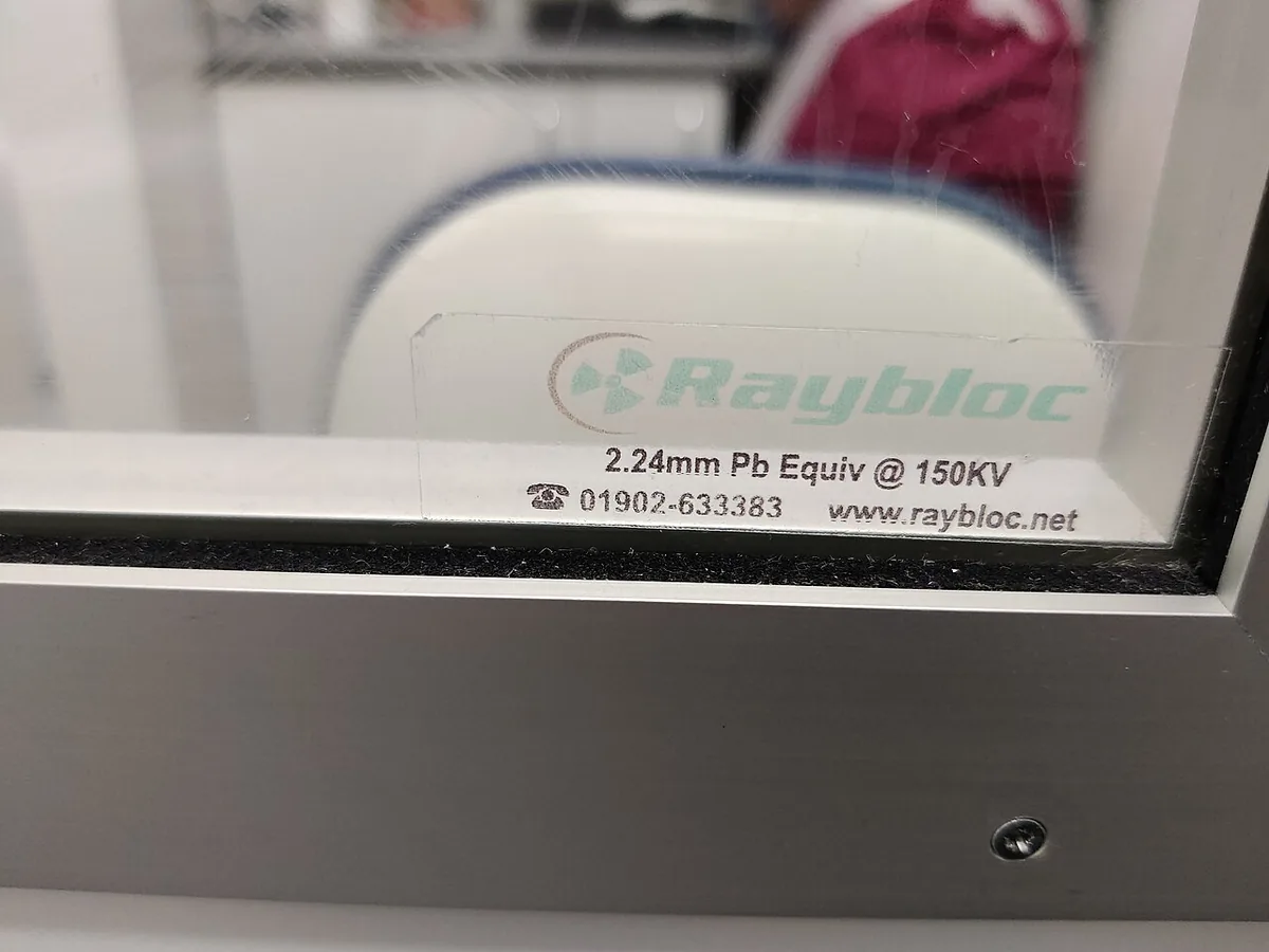 Fenêtre de protection radiologique en verre au plomb installée dans une cloison de salle de radiologie