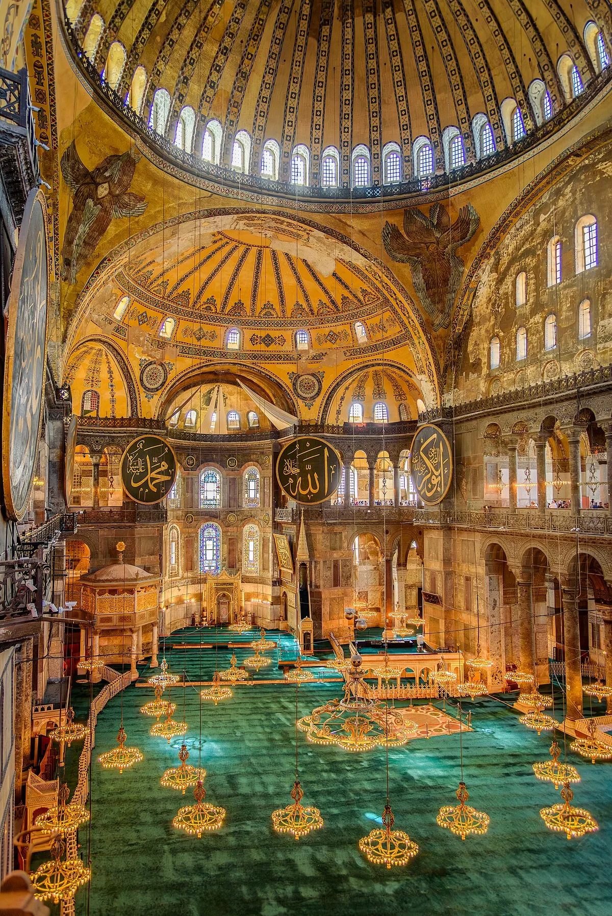 Intérieur de la mosquée Sainte-Sophie à Istanbul montrant la nef, la coupole centrale et les grands médaillons calligraphiés