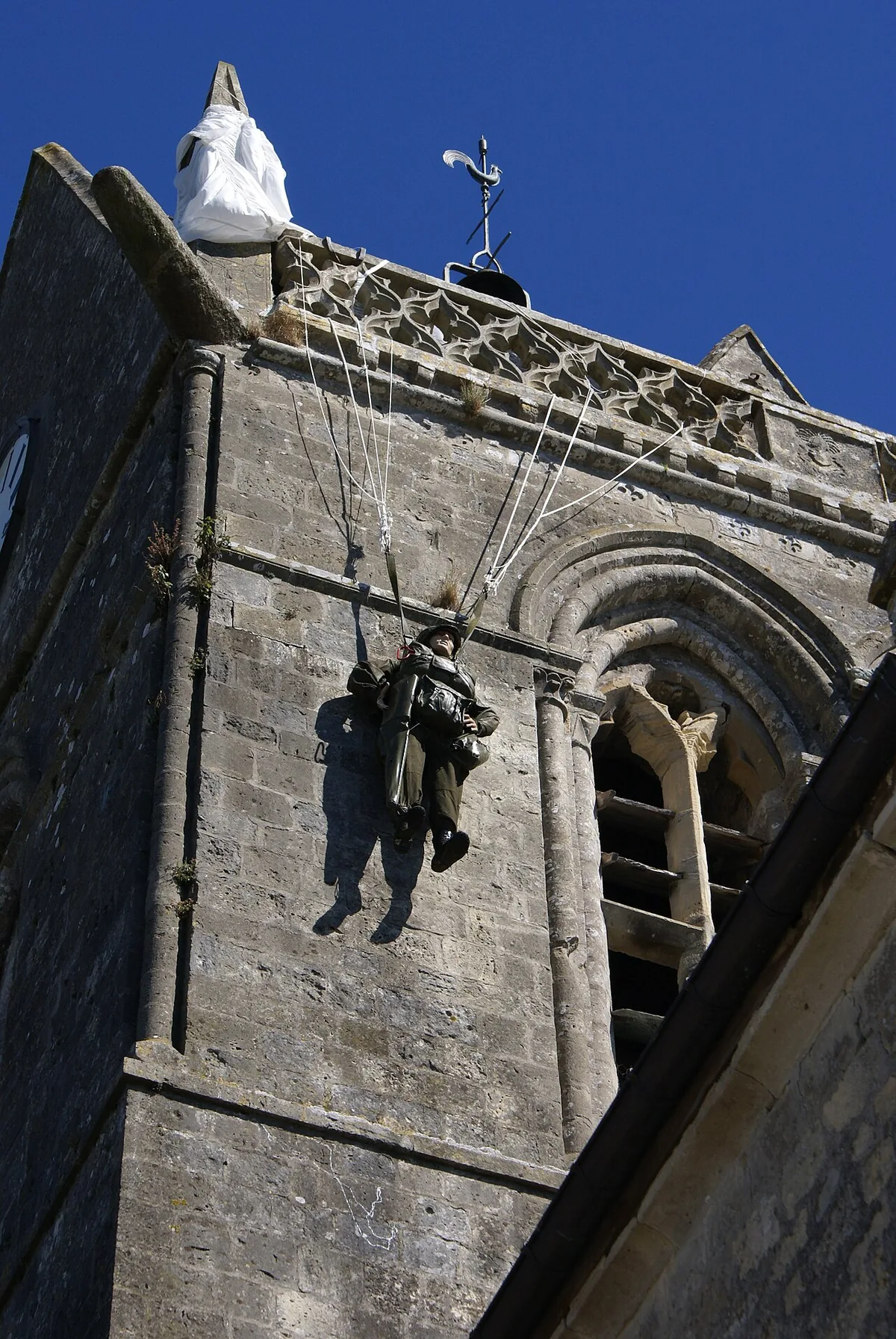 Mannequin de parachutiste suspendu au clocher de l'église de Sainte-Mère-Église en mémoire de John Steele accroché la nuit du 6 juin 1944