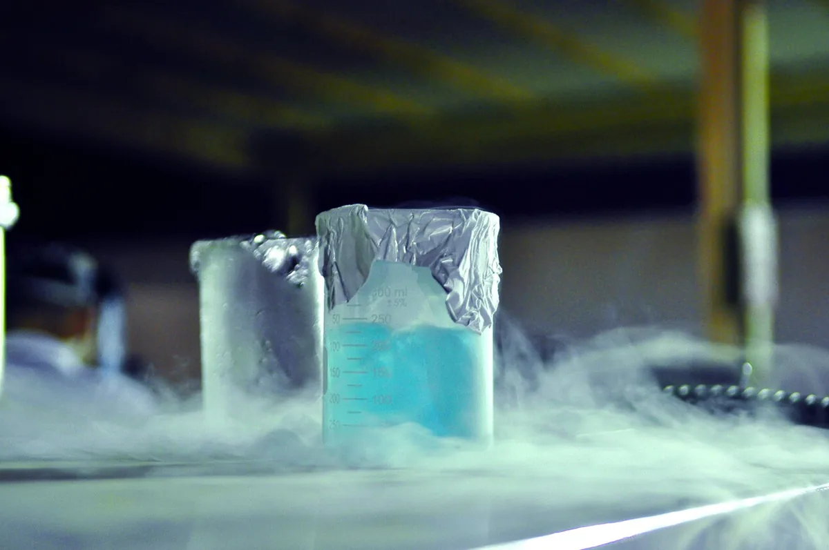 Oxygène liquide bleu pâle dans un bécher de laboratoire, forme cryogénique du dioxygène refroidi