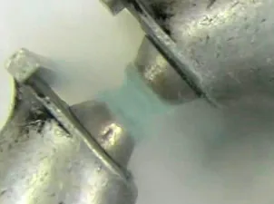 Oxygène liquide bleu suspendu entre les pôles d'un aimant, démontrant le paramagnétisme du dioxygène