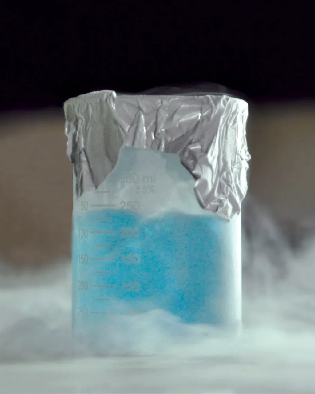 Oxygène liquide de couleur bleu cyan pâle contenu dans un becher de laboratoire, à moins 183 degrés Celsius