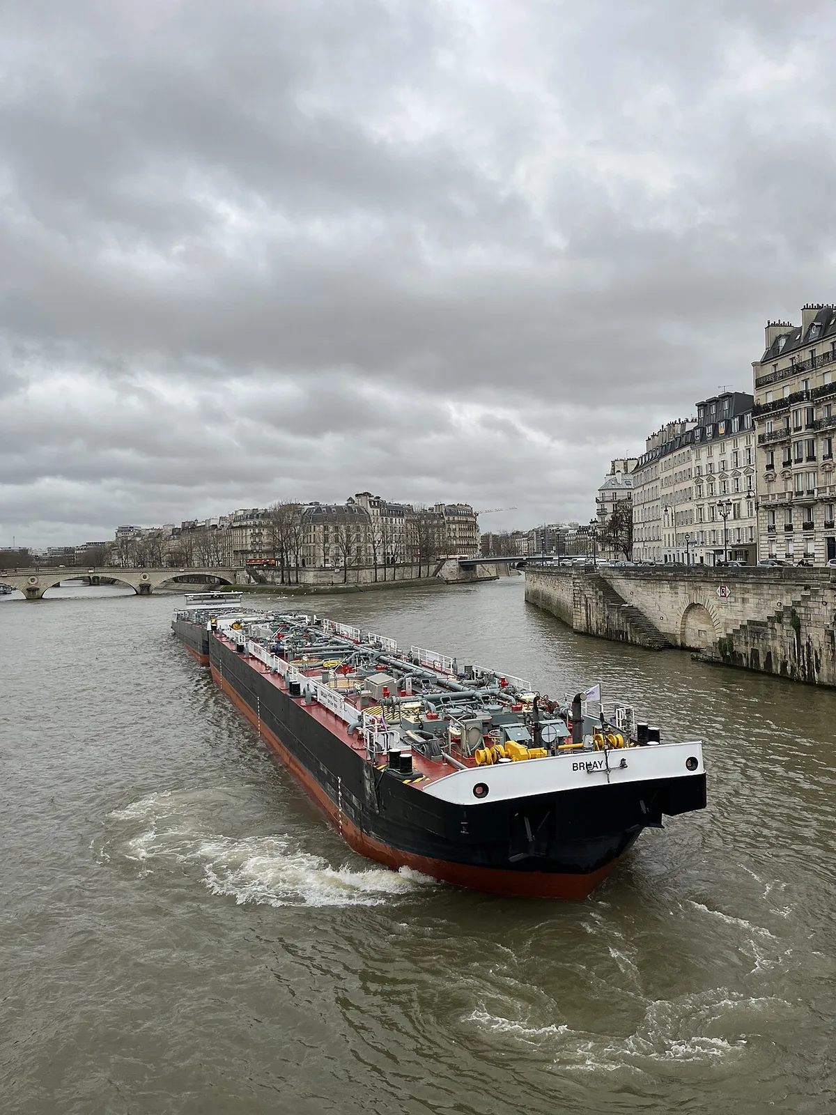 Peniche de transport de marchandises naviguant sur la Seine avec l'ile de la Cite en arriere-plan