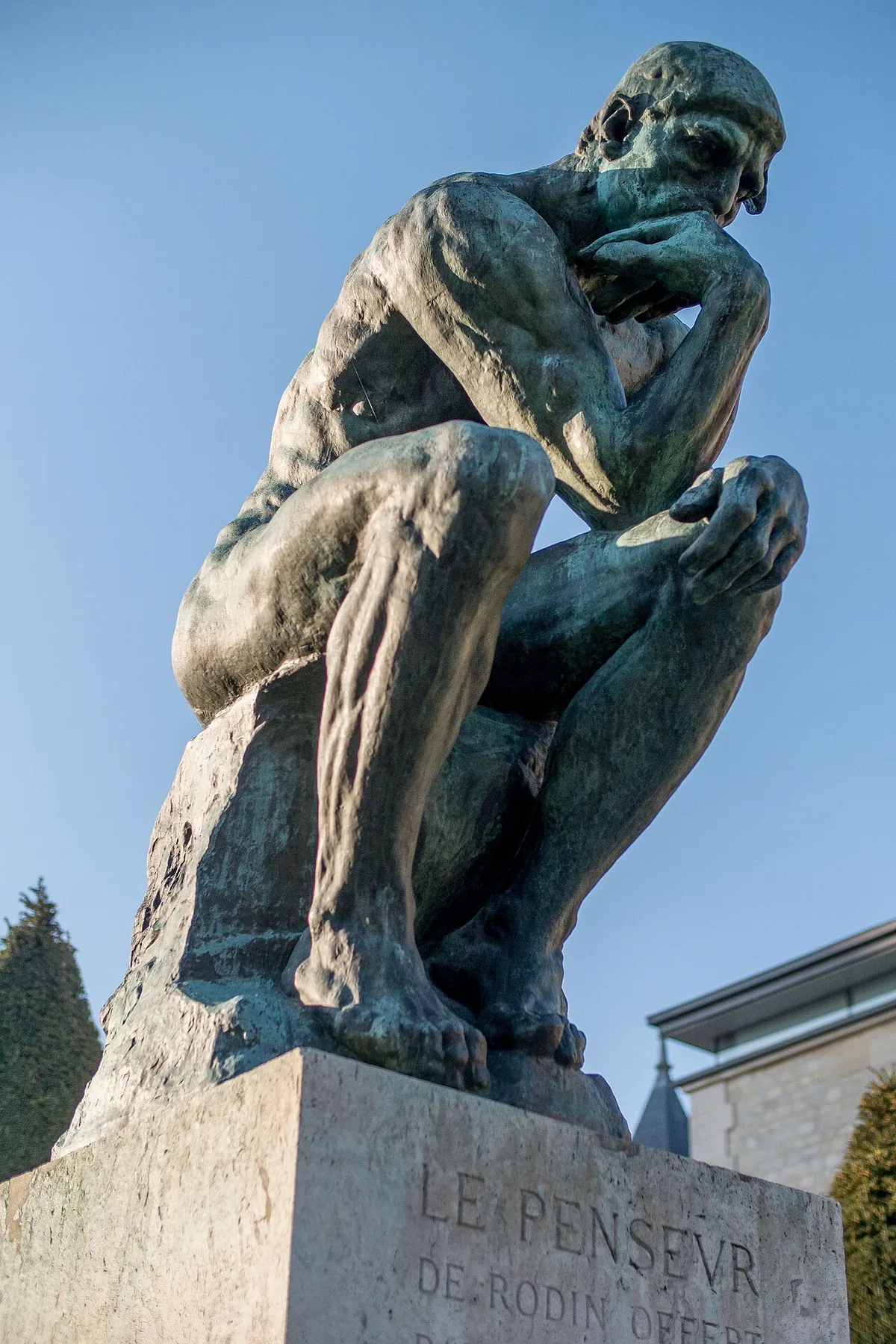 Le Penseur en bronze installé dans les jardins du musée Rodin à Paris, sur son socle de pierre
