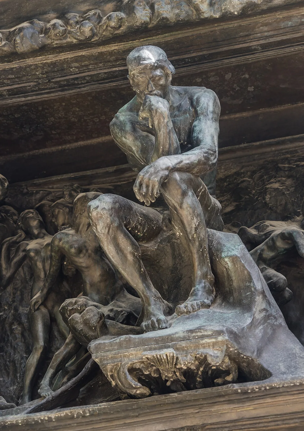 Le Penseur au sommet du tympan de La Porte de l'Enfer, dans sa position d'origine dominant les damnés