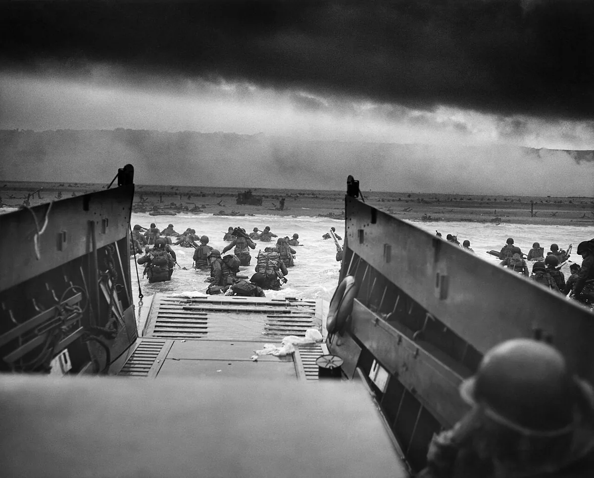 Soldats américains de la 1re division d'infanterie quittant une péniche sous le feu allemand vers Omaha Beach le 6 juin 1944