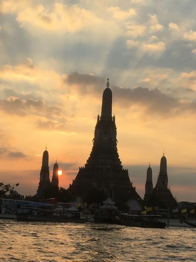 Le temple Wat Arun se dresse au bord du fleuve Chao Phraya au coucher du soleil à Bangkok