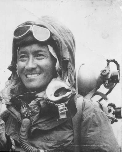 Tenzing Norgay au sommet de l'Everest le 29 mai 1953, brandissant son piolet orné de fanions