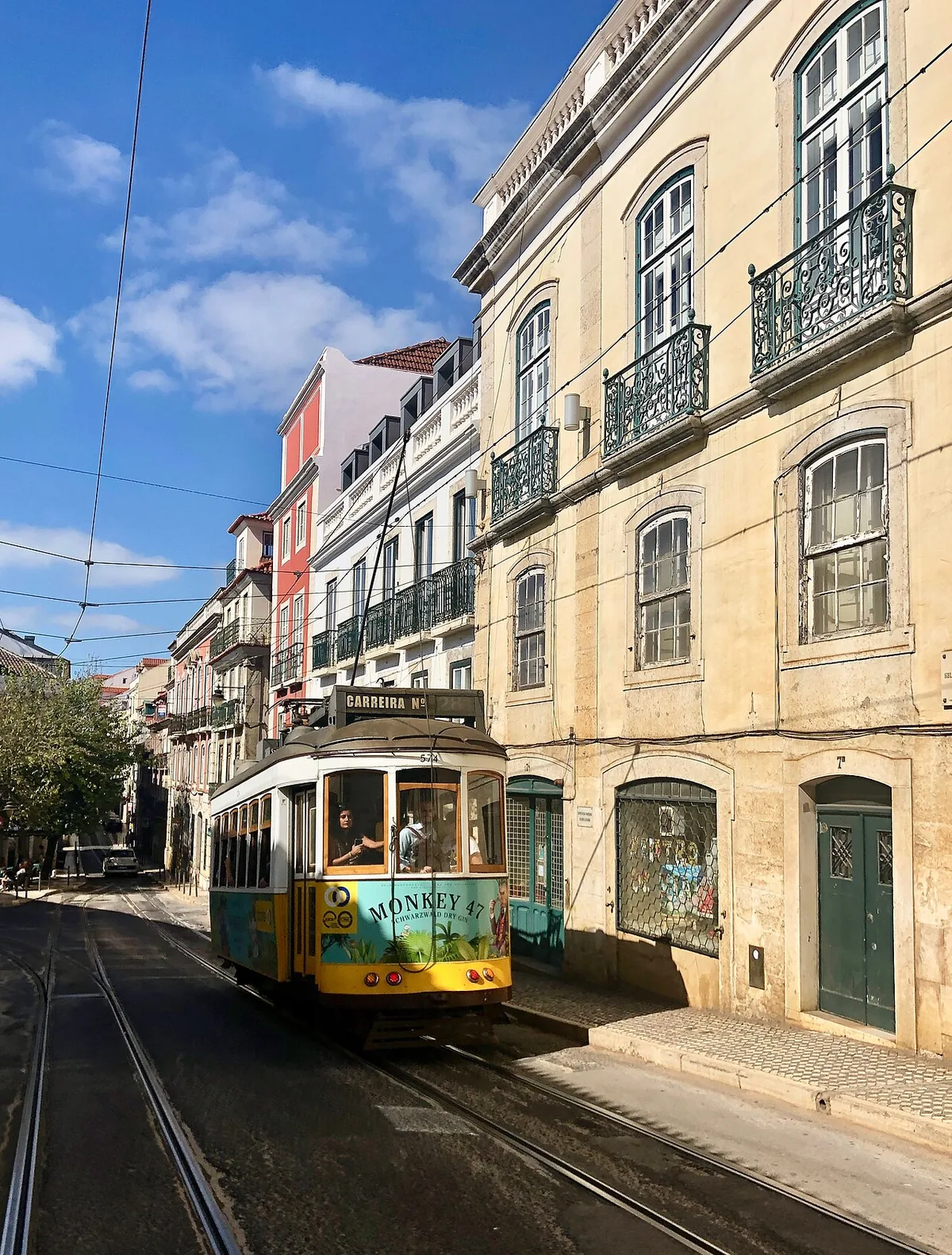 Tramway jaune de la ligne 28 dans une rue en pente de Lisbonne