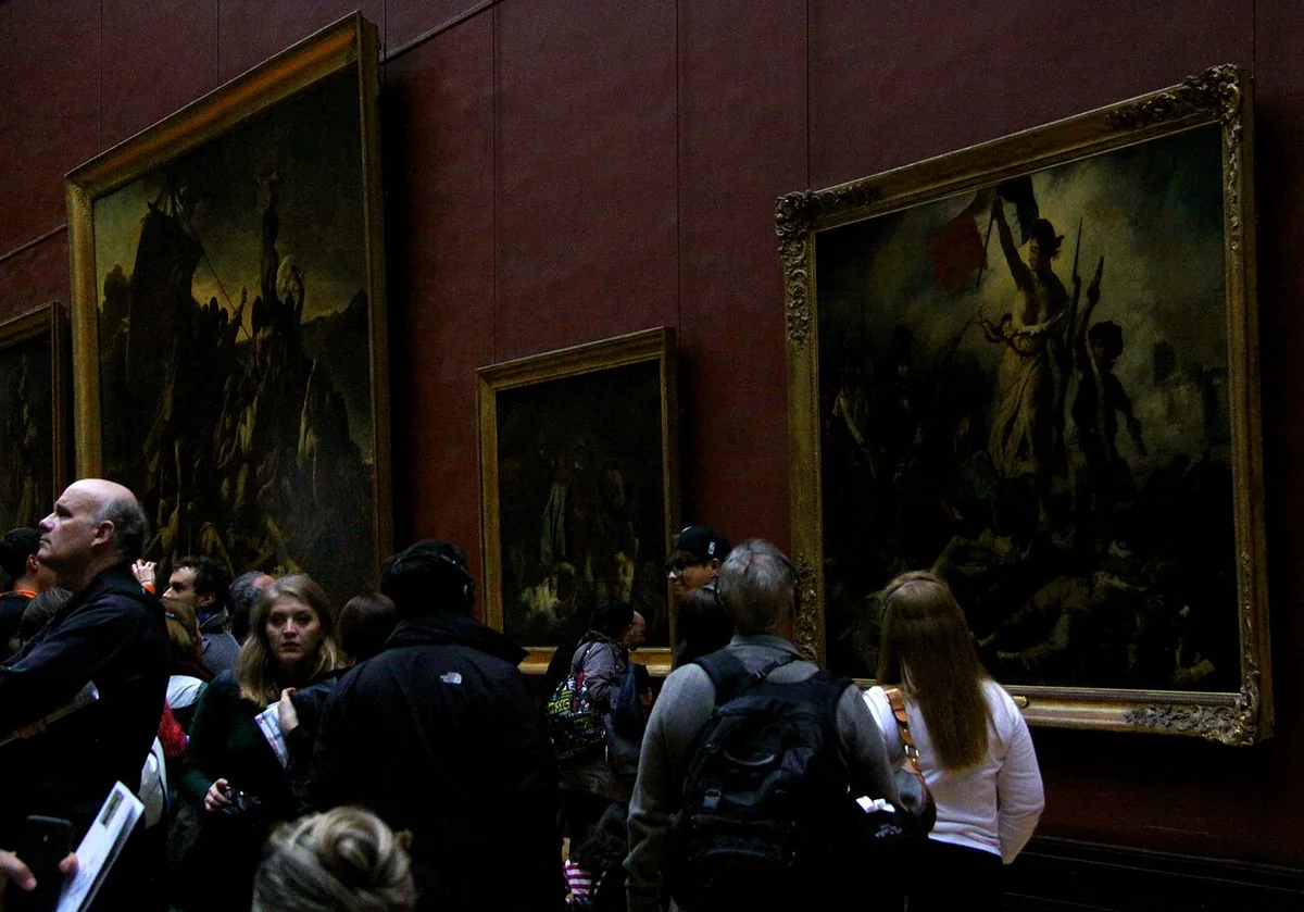 Visiteurs du Louvre rassemblés devant La Liberté guidant le peuple accrochée dans la salle Mollien