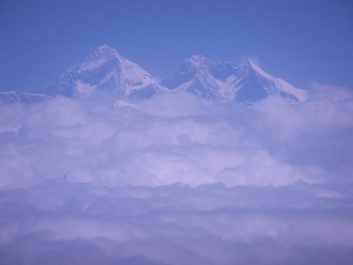 Vue aérienne du sommet enneigé de l'Everest dominant la chaîne de l'Himalaya sous un ciel dégagé